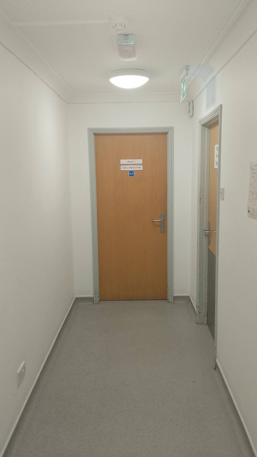 A light corridor ending in a timber door with a newly painted frame