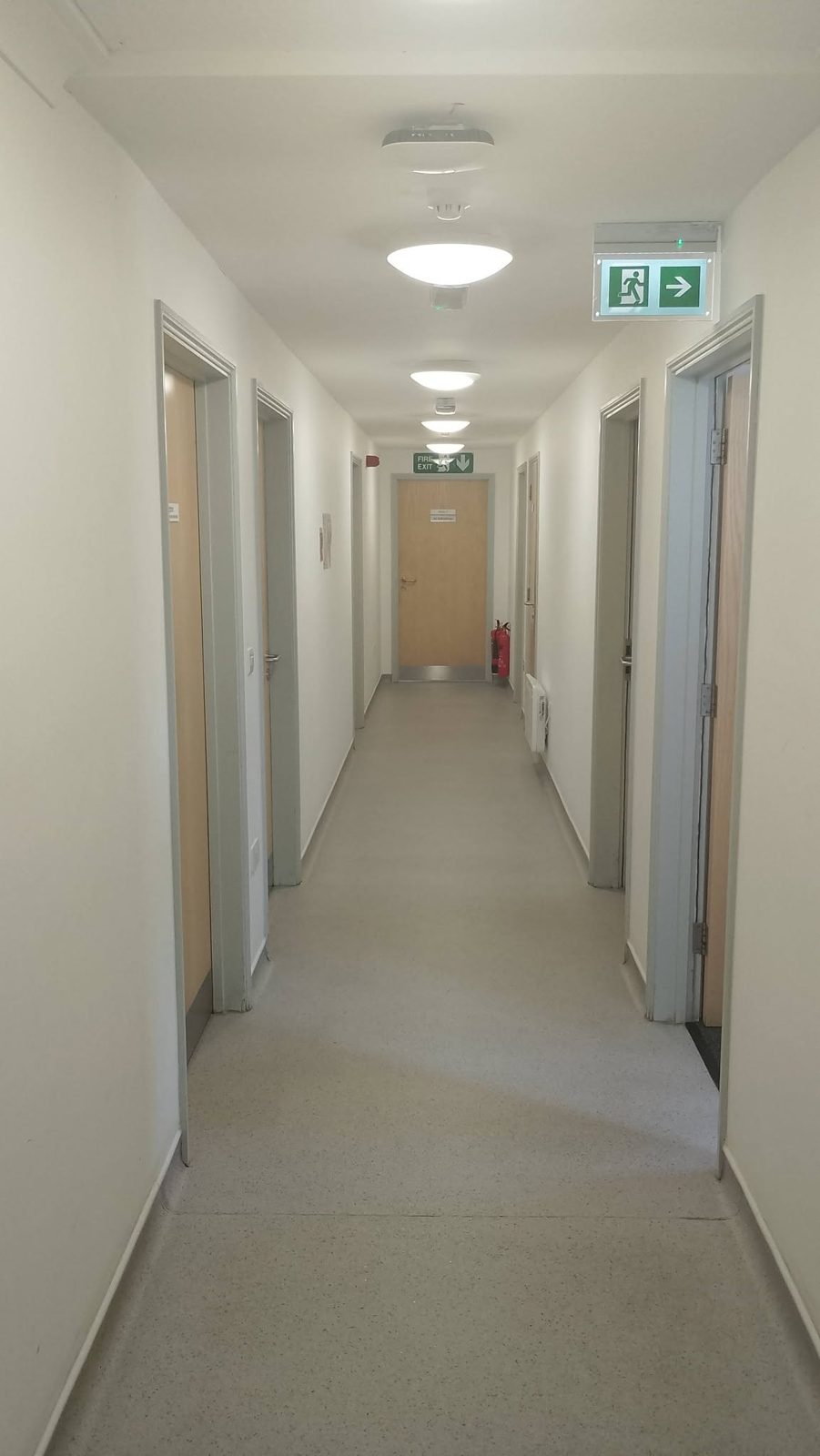 A long surgery corridor with painted walls and door frames