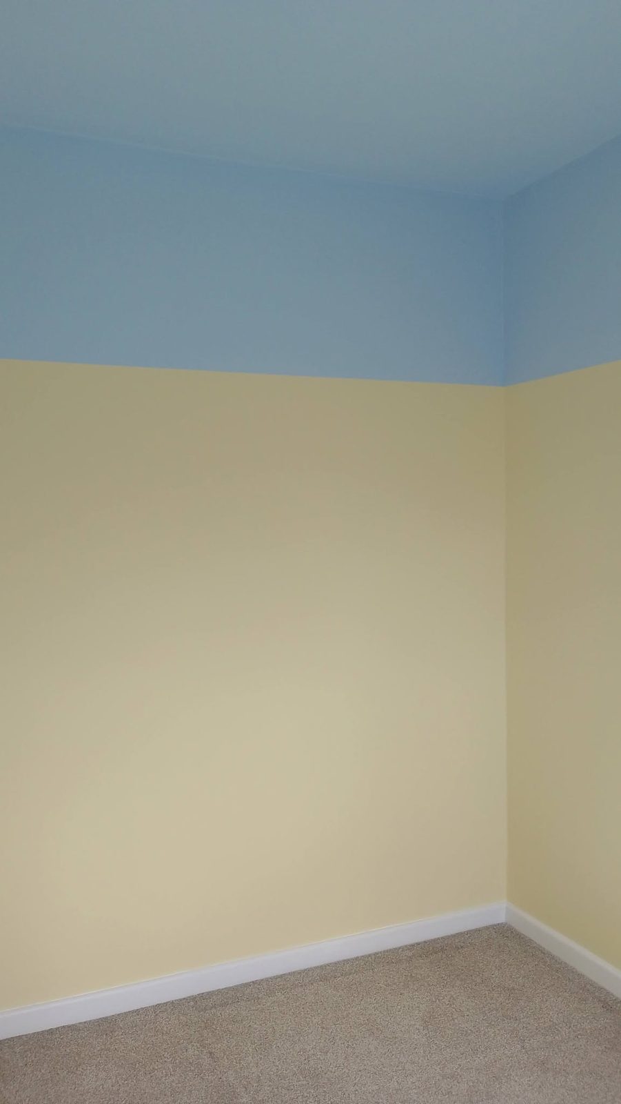 The same bedroom finished in pale yellow with a sky blue band at the top