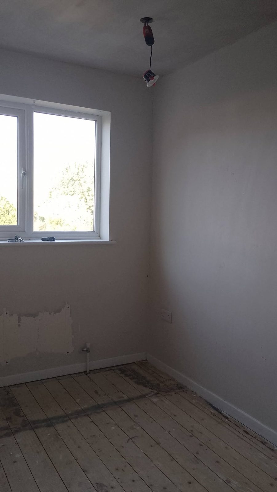 A bedroom with prepared walls, before painting