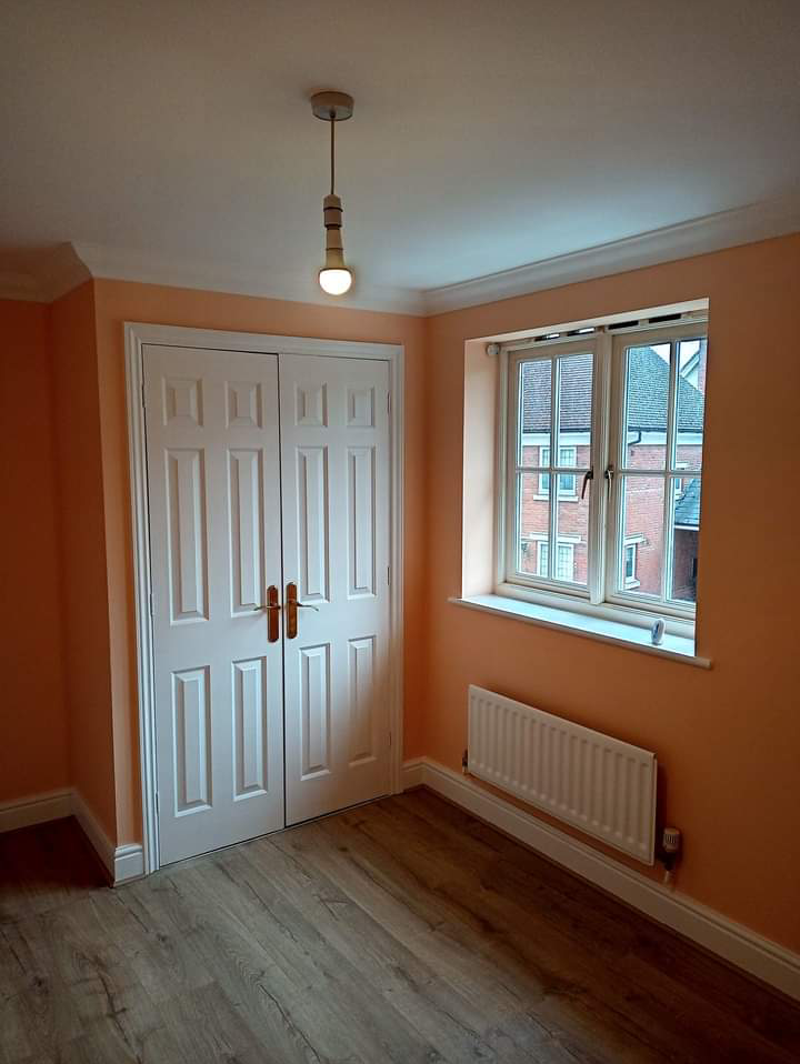 Warm peach room with white double doors and a white window